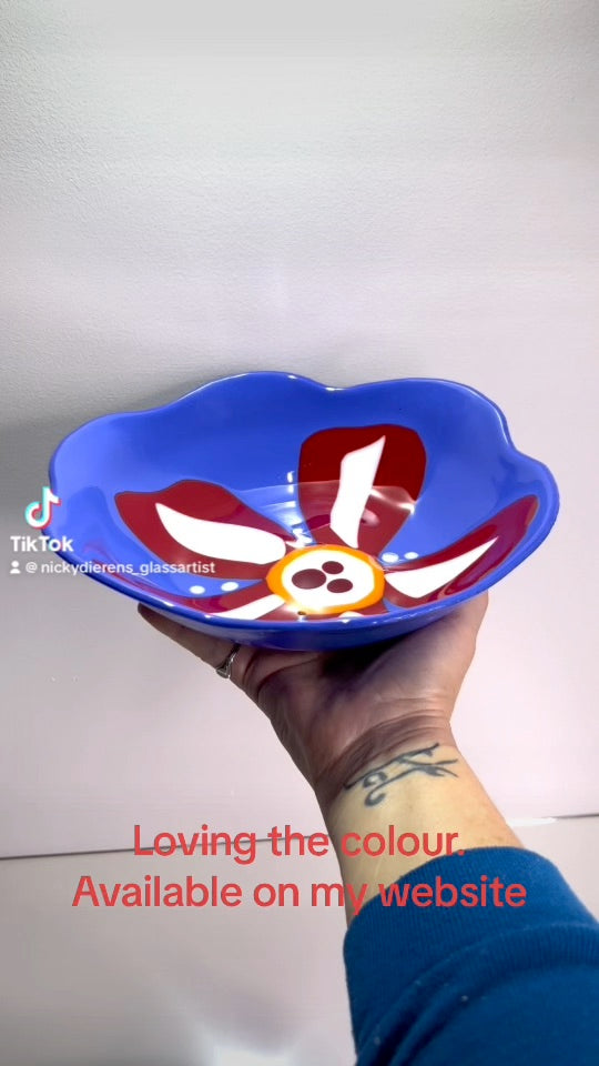 Blue glass bowl with red and white flower