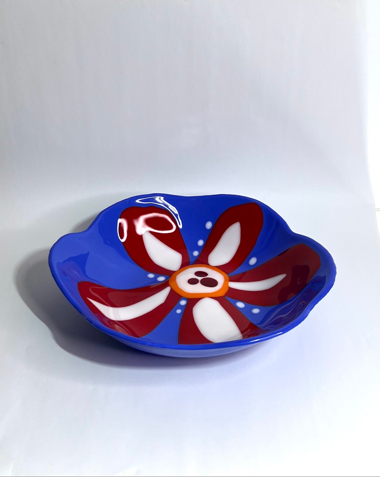 Blue glass bowl with red and white flower