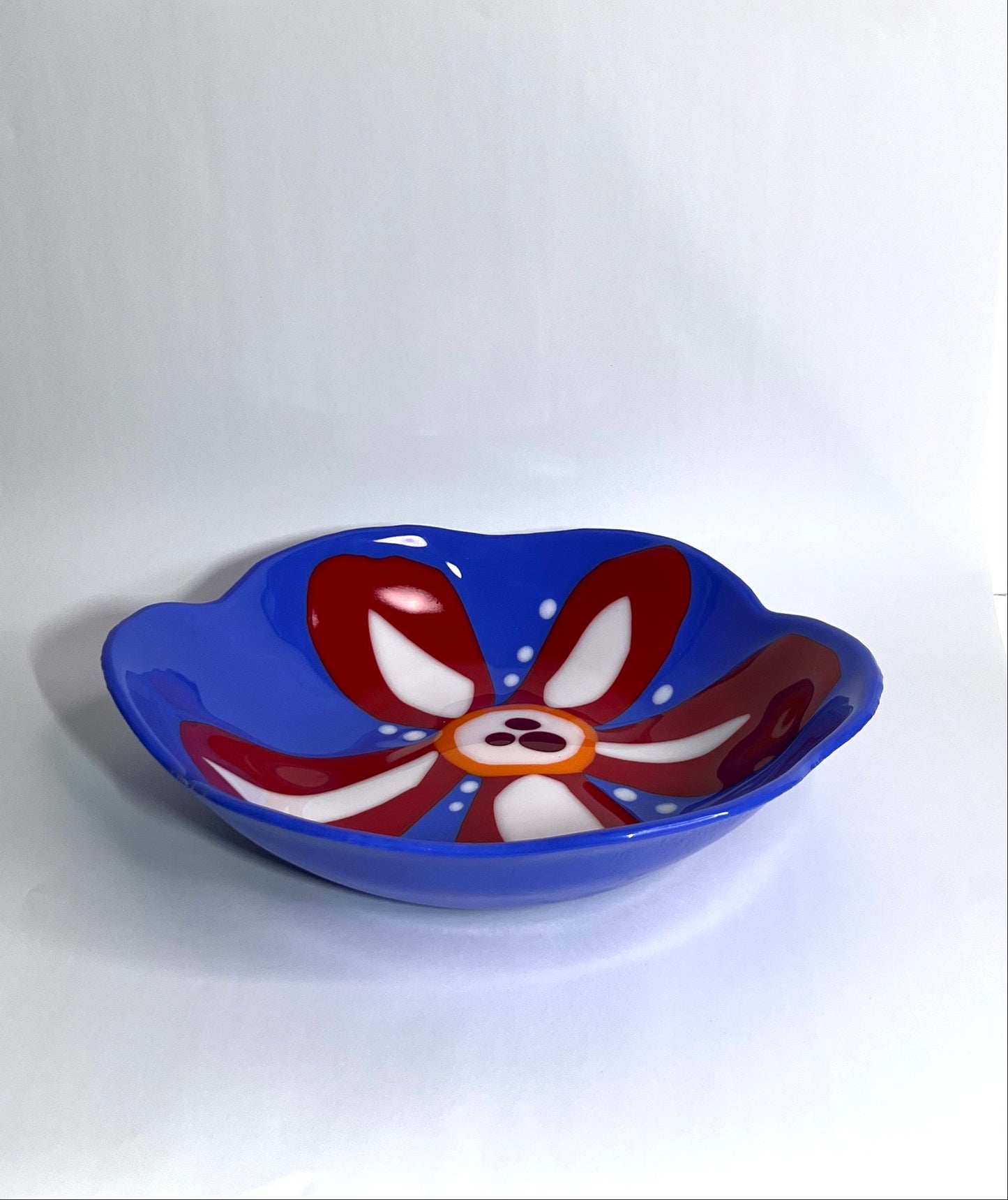 Blue glass bowl with red and white flower
