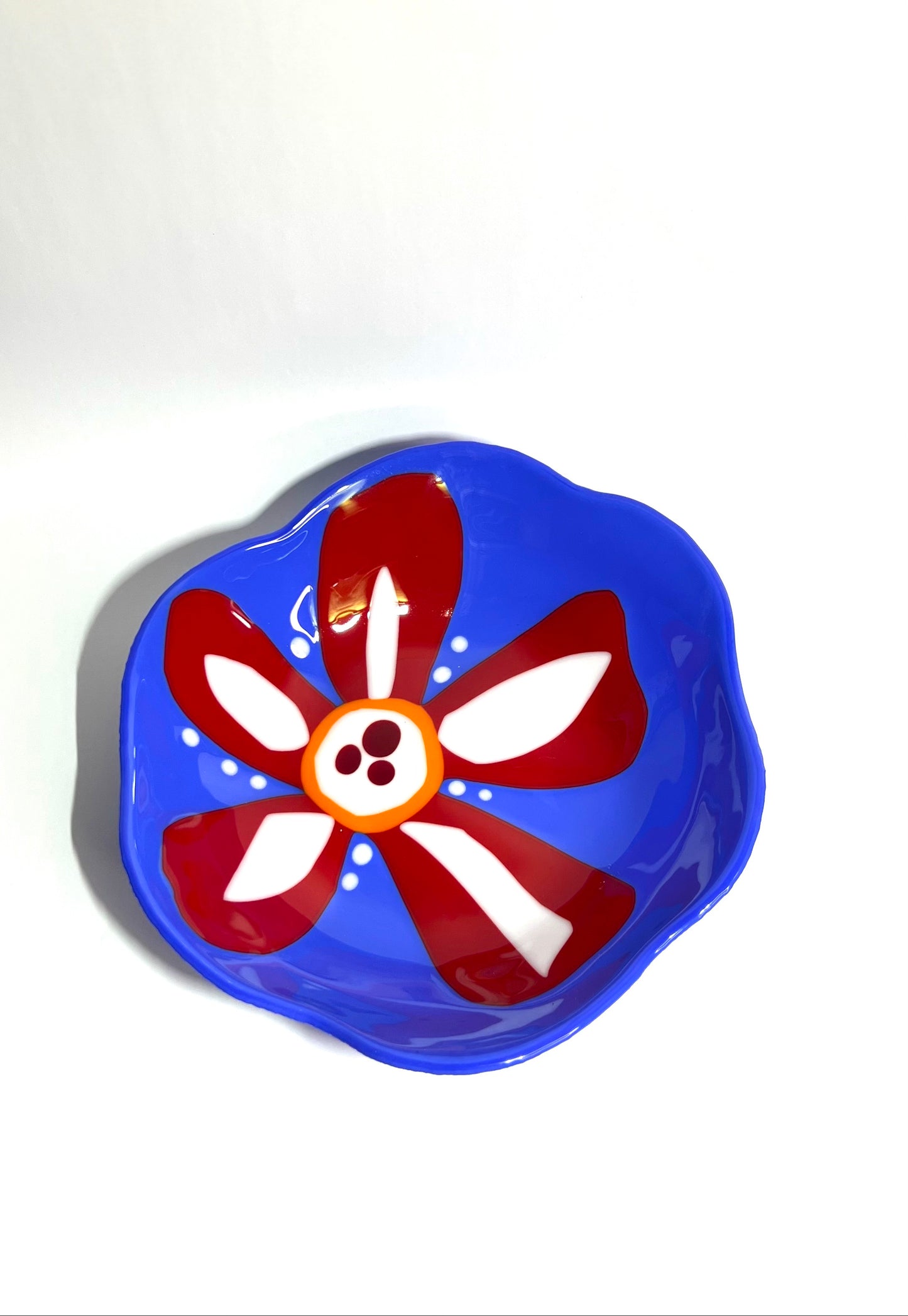 Blue glass bowl with red and white flower