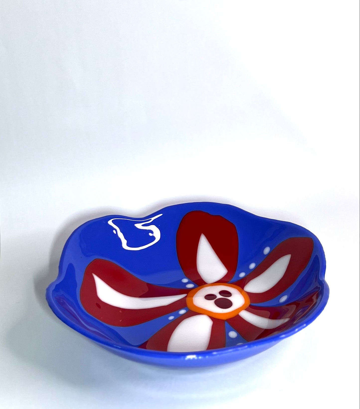 Blue glass bowl with red and white flower