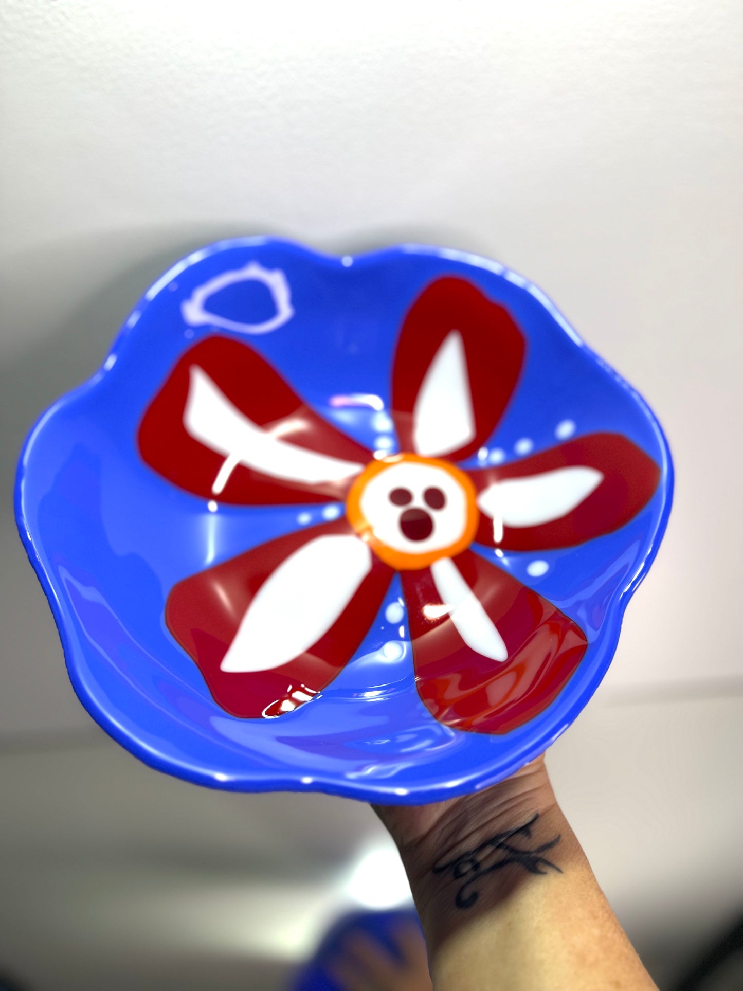 Blue glass bowl with red and white flower