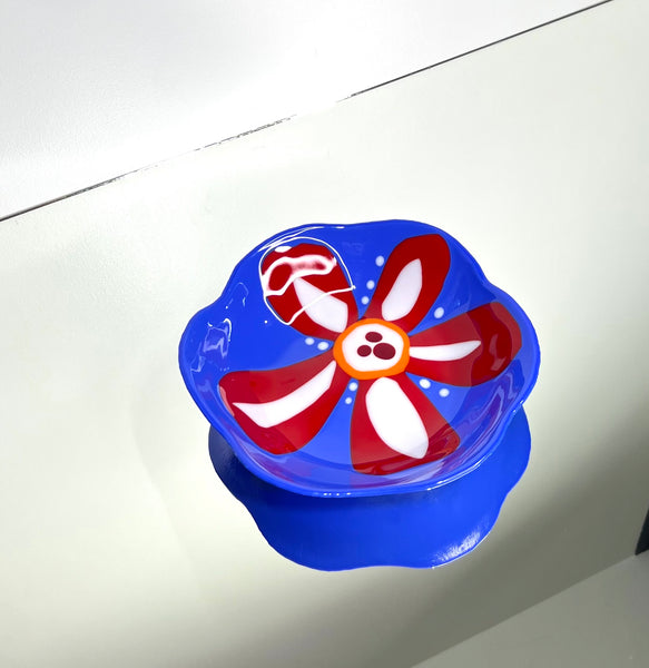 Blue glass bowl with red and white flower