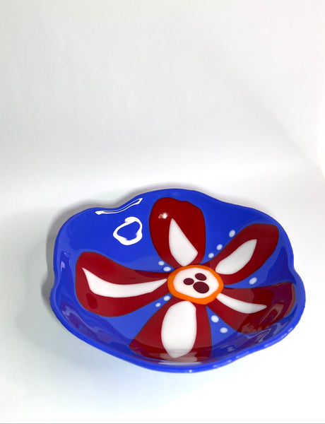 Blue glass bowl with red and white flower